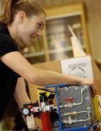 A student docent demonstrates a portable fuel cell power system